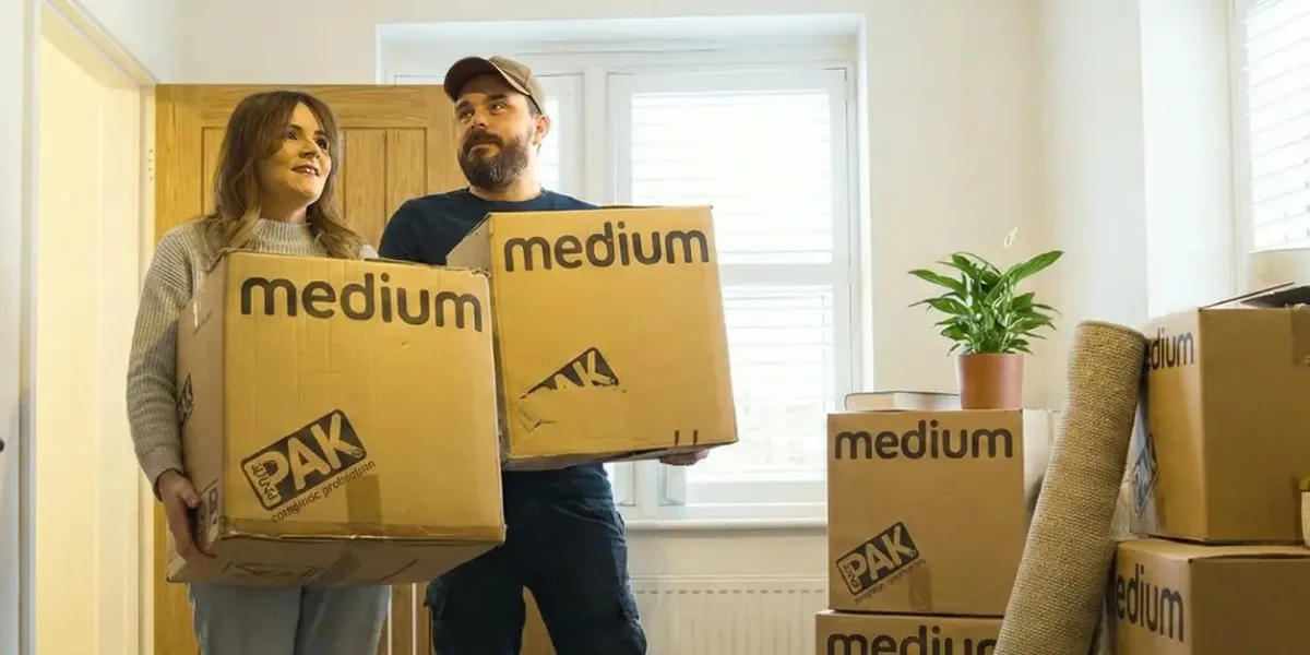 Couple moving boxes into a first time home storage unit